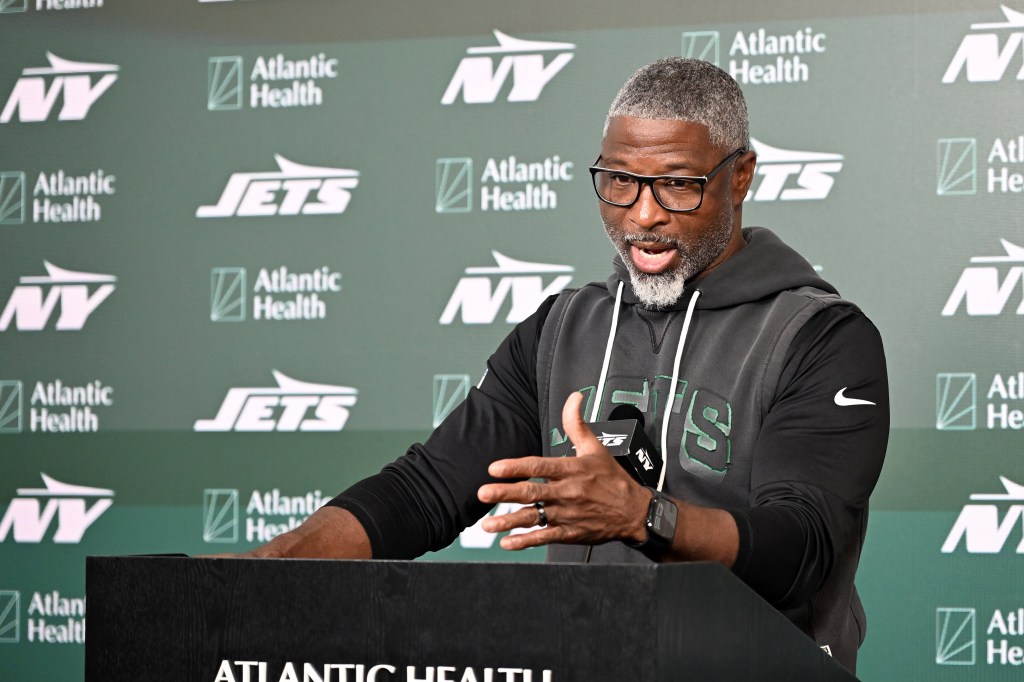 Jets head coach Aaron Glenn speaks at a podium.