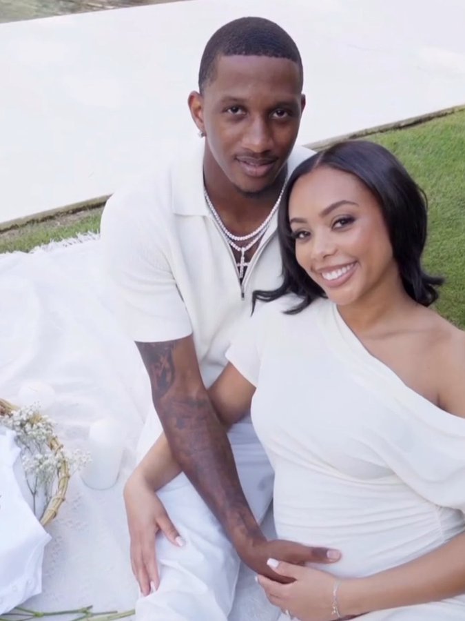 Michael Penix Jr. and his wife wearing matching white outfits outdoors.