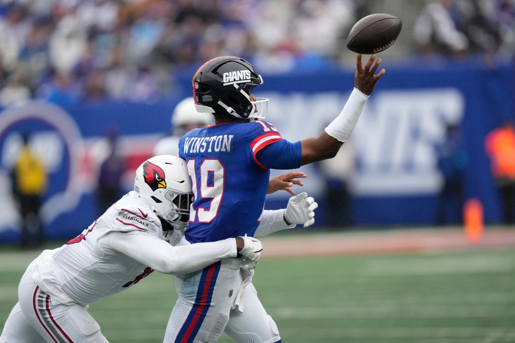 New York Giants quarterback Jameis Winston throws the ball as he is hit by Arizona Cardinals linebacker Josh Sweat.