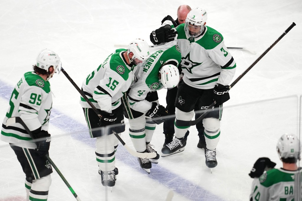 Dallas Stars defenseman Miro Heiskanen (4) is helped off the ice by center Colin Blackwell (15) and defenseman Mathew Dumba (3) after sustaining an injury from a trip by Vegas Golden Knights right wing Mark Stone (not pictured) during the third period at T-Mobile Arena.