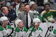 Dallas Stars head coach Peter DeBoer, back center, looks on from the team box in the second...