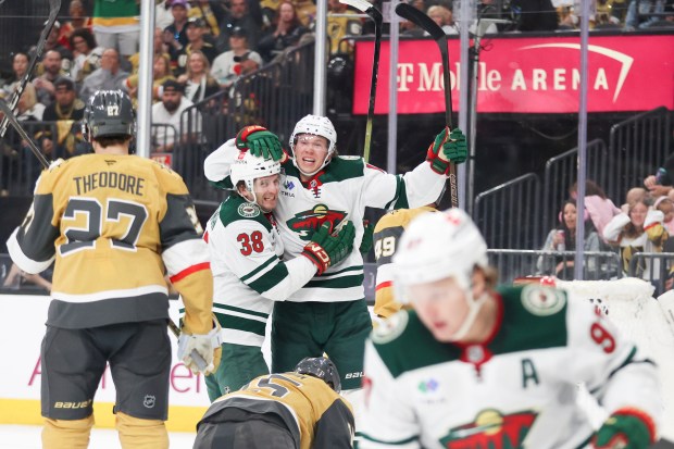 Minnesota Wild right wing Ryan Hartman (38) and left wing Matt Boldy (12) celebrate after Boldy's goal during the third period in Game 1 of an NHL hockey Stanley Cup first-round playoff series against the Vegas Golden Knights Sunday, April 20, 2025, in Las Vegas. (AP Photo/Ian Maule)