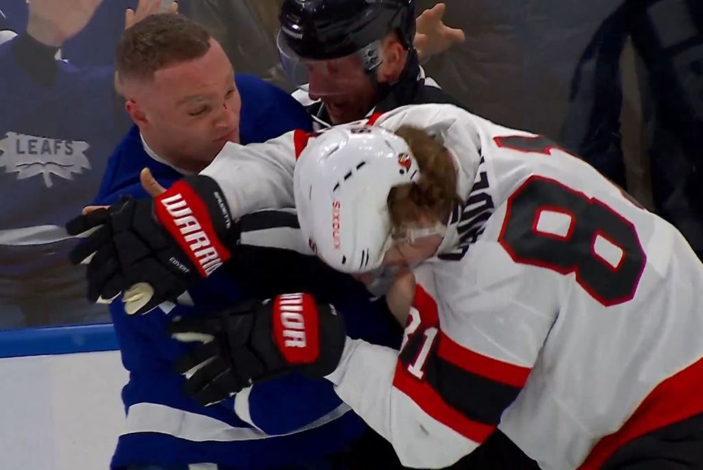 The Maple Leafs' Max Domi (l.) lands a punch on the Senators' Adam Gaudette (r.) on April 20, 2025.