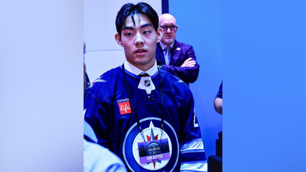 A young man wearing a hockey jersey 