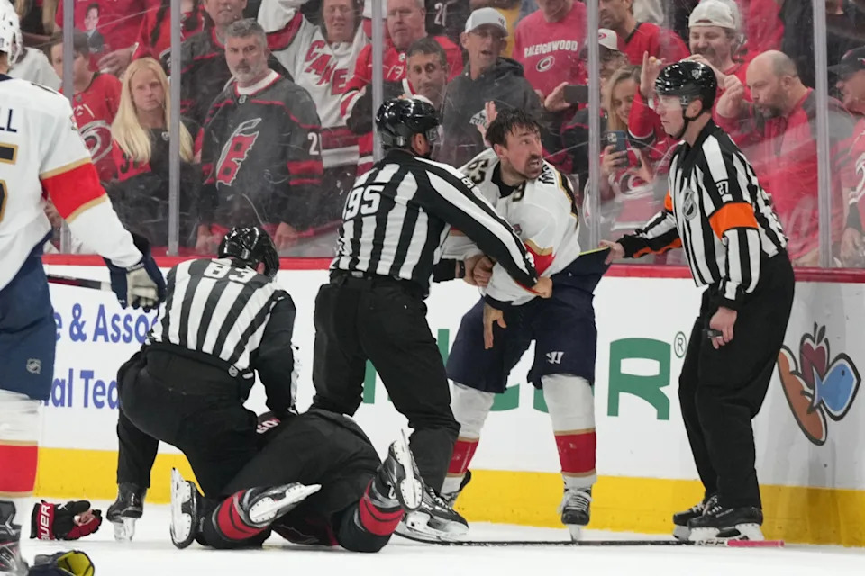 Florida Panthers forward Brad Marchand (63) fights Carolina Hurricanes defenseman Shayne Gostibehere (4) at Lenovo Center.James Guillory-Imagn Images