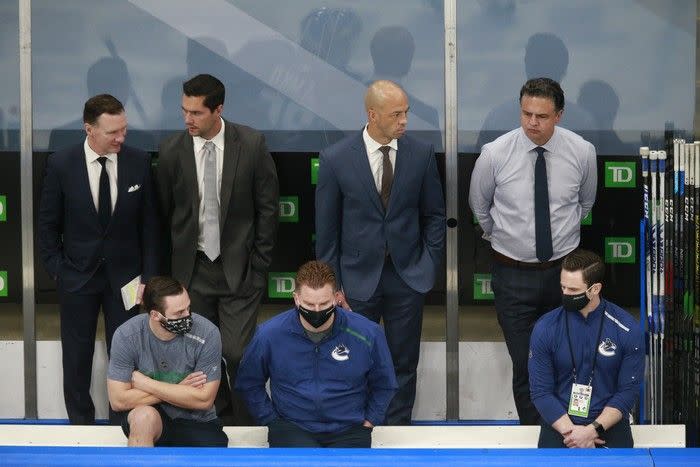 (L-R) Newell Brown, Nolan Baumgartner, Manny Malhotra and Travis Green of the Vancouver Canucks watch warm-ups prior to their game against the St. Louis Blues in Game Six of the Western Conference First Round during the 2020 NHL Stanley Cup Playoffs.