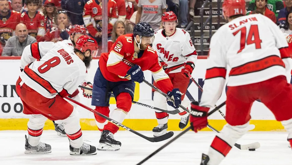 Florida Panthers left wing A.J. Greer (10) looks to pass the puck as Carolina Hurricanes defenseman Brent Burns (8) defends in the second period of Game 3 during the Eastern Conference final of the NHL Stanley Cup playoffs at Amerant Bank Arena on Saturday, May 24, 2025, in Sunrise, Fla.