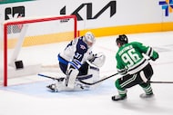 Winnipeg Jets goaltender Connor Hellebuyck (37) blocks a shot by Dallas Stars right wing...
