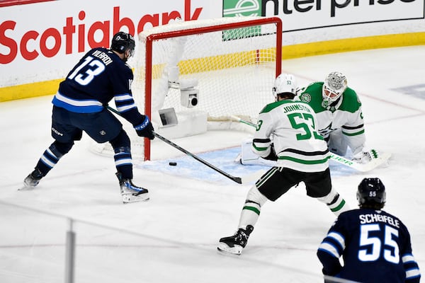 Winnipeg Jets' Gabriel Vilardi (13) scores against Dallas Stars goaltender Jake Oettinger, top right, during the first period of Game 2 of a second-round NHL hockey playoff series in Winnipeg, Manitoba, Friday, May 9, 2025. (Fred Greenslade/The Canadian Press via AP)