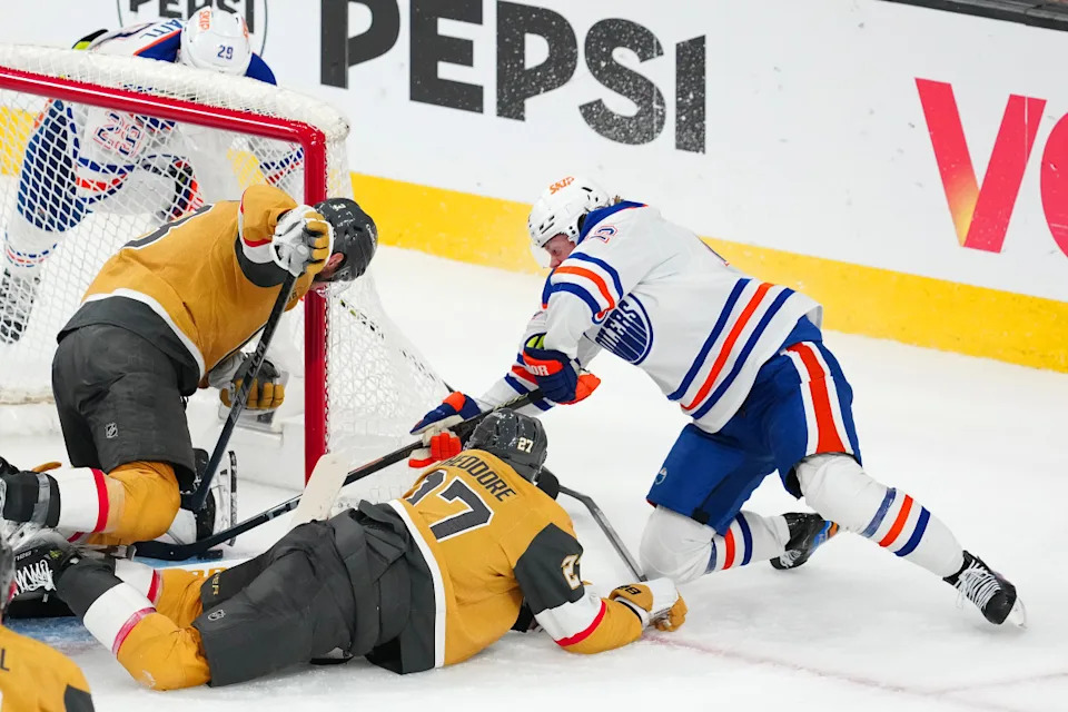 Oilers right wing Kasperi Kapanen (right) digs the puck out from under the skate of Golden Knights goaltender Adin Hill and puts it into the net 7:19 into overtime of Game 5 at T-Mobile Arena in Las Vegas. The Oilers' 1-0 win eliminated the Knights from the playoffs.Stephen R&period; Sylvanie-Imagn Images