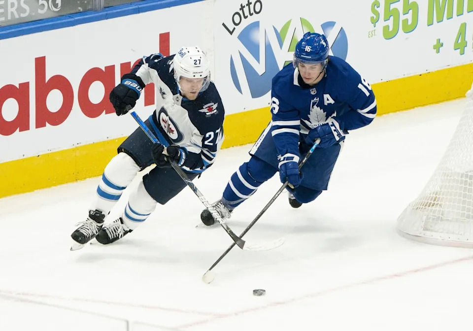Toronto Maple Leafs center Mitch Marner (16) skates with the puck as Winnipeg Jets left wing Nikolaj Ehlers (27) tries to defend during the first period at Scotiabank Arena. Nick Turchiaro-Imagn Images