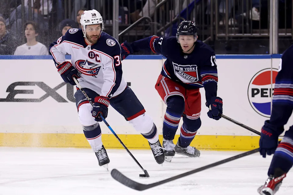 Mar 9, 2025; New York, New York, USA; Columbus Blue Jackets center Boone Jenner (38) plays the puck against New York Rangers defenseman Will Borgen (17) during the first period at Madison Square Garden. Mandatory Credit: Brad Penner-Imagn Images