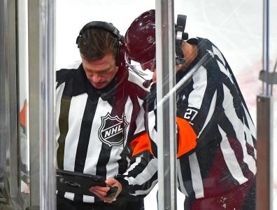 Referees Kelly Sutherland and Eric Furlatt looking over a replay during a playoff game in 2021.