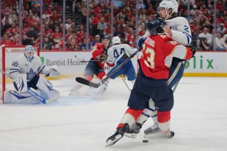 Toronto Maple Leafs defenseman Simon Benoit finishing a check against Florida Panthers forward Brad Marchand