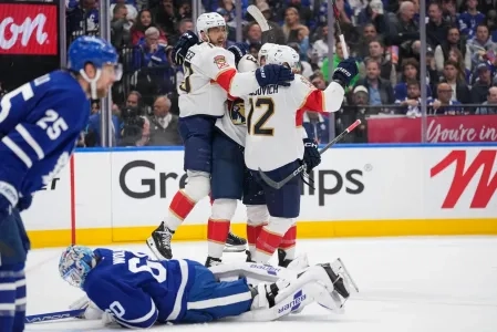 Toronto Maple Leafs defenseman Brandon Carlo looking onwards as the Florida Panthers celebrate a goal being scored.
