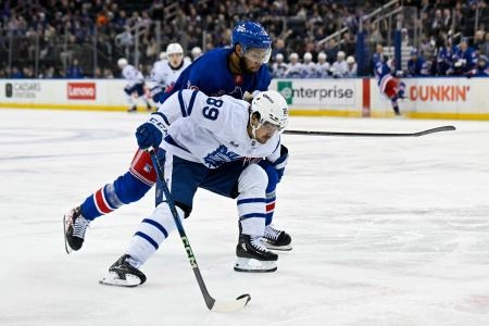 Toronto Maple Leafs forward Nicholas Robertson battling for position against New York Rangers defenseman K'Andre Miller. Toronto Maple Leafs forward Nicholas Robertson battling for position against New York Rangers defenseman K'Andre Miller.
