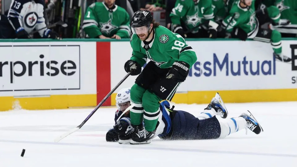 Dallas Stars' Sam Steel is tripped by Winnipeg Jets' Mark Scheifele as Steel chases after the puck with seconds left in regulation time. - Gareth Patterson/AP