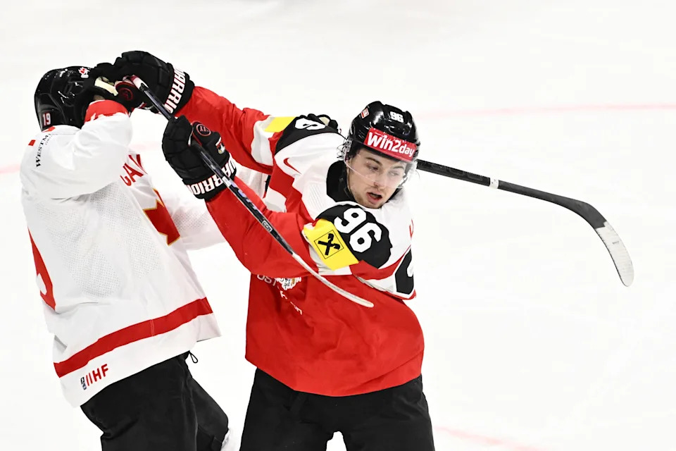 Canada forward Adam Fantilli is in a fight with Austria forward Marco Kasper (96) during the IIHF Men's Ice Hockey World Championship Group A match between Canada and Austria at Avicii Arena in Stockholm, on May 15, 2025.