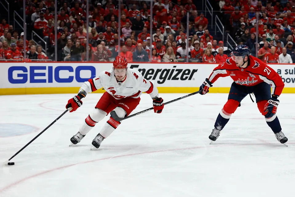 May 6, 2025; Washington, District of Columbia, USA; Carolina Hurricanes defenseman Dmitry Orlov (7) skates with the puck as Washington Capitals center Aliaksei Protas (21) chases in the third period in game one of the second round of the 2025 Stanley Cup Playoffs at Capital One Arena. Mandatory Credit: Geoff Burke-Imagn Images