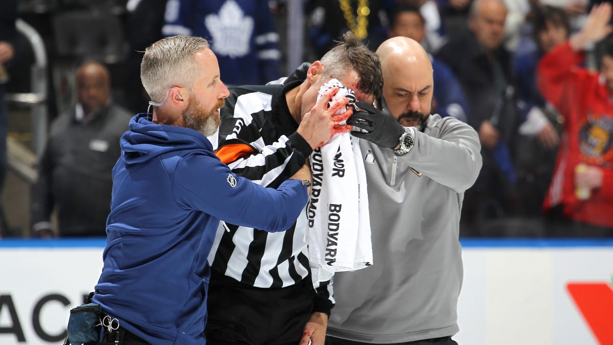 Referee Chris Rooney leaves NHL playoff game after being hit by stick