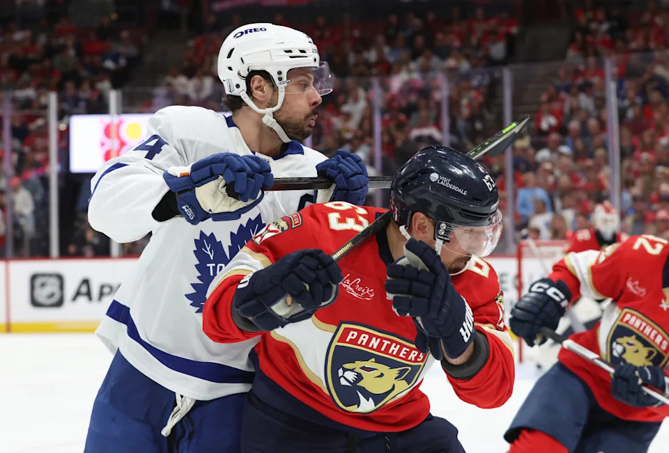 Toronto Maple Leafs center Auston Matthews (34) and Florida Panthers center Brad Marchand (63) fight to control the puck at Amerant Bank Arena.Kim Klement Neitzel-Imagn Images