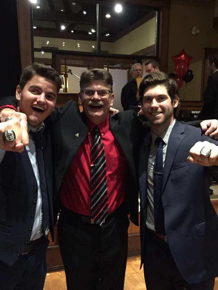 Cameron Critchlow, left, with his former UNB coach Gardiner MacDougall, centre, show off their championship rings.