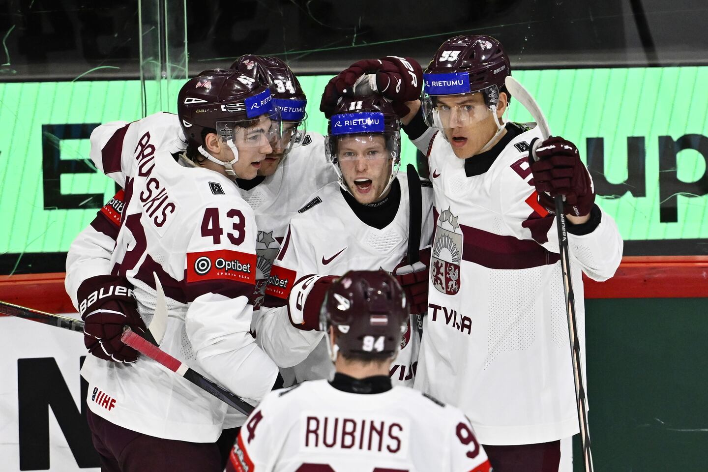 Dans Locmelis (center) celebrates with teammates after scoring against Slovenia in the World Championship.