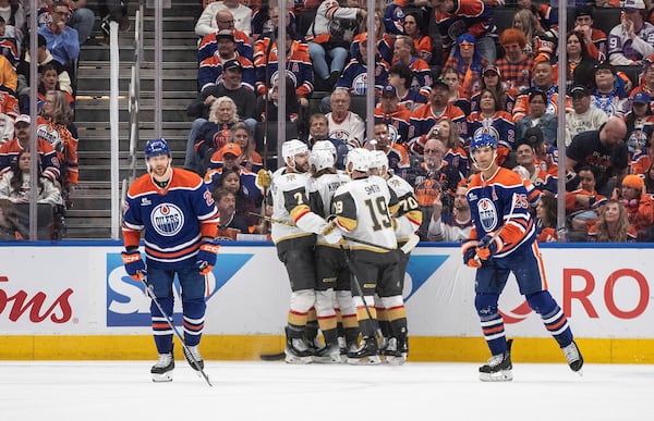 Vegas Golden Knights players, center, celebrate after a goal as Edmonton Oilers' Brett Kulak (27) and Darnell Nurse (25) skate past during the second period of Game 3 of a second-round NHL hockey playoff series in Edmonton, Alberta, Saturday, May 10, 2025. (Jason Franson/The Canadian Press via AP)