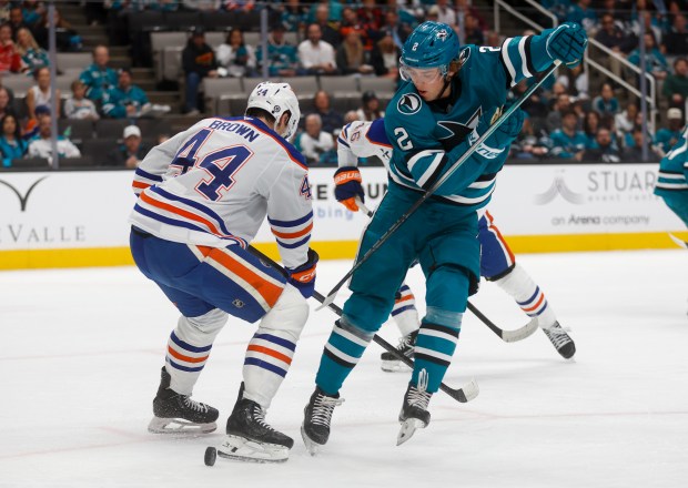 San Jose Sharks' Will Smith (2) tries to control the...