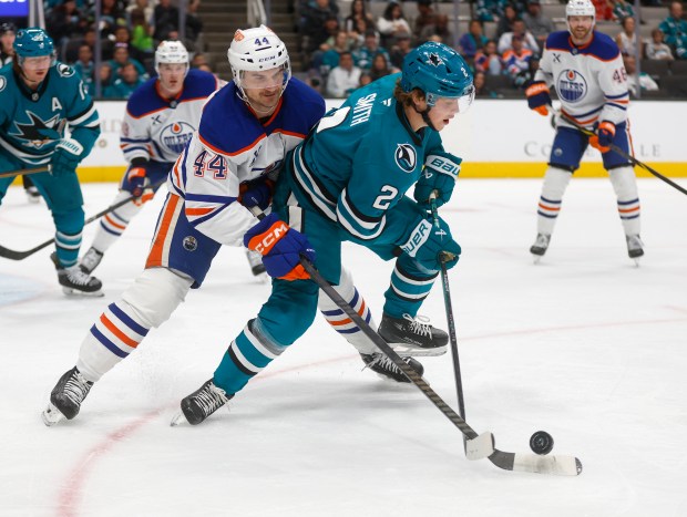 San Jose Sharks' Will Smith (2) fights for the puck...