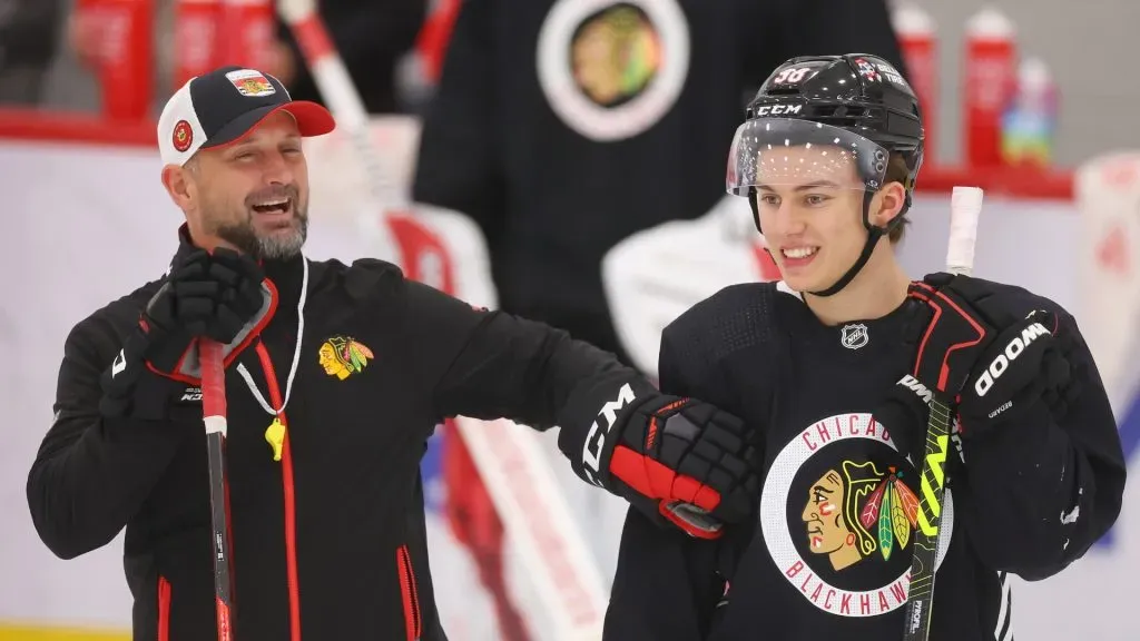 Connor Bedard #98 of the Chicago Blackhawks laughs with coach Anders Sorensen during Prospect Camp practice at Fifth Third Arena on September 14, 2023 in Chicago, Illinois.