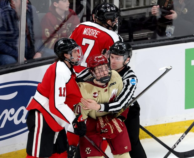 A game official holds back Boston College forward James Hagens after a scuffle during a Beanpot semifinal against Northeastern on April 18, 2025, at TD Garden in Boston. (Mark Stockwell/for the Boston Herald)