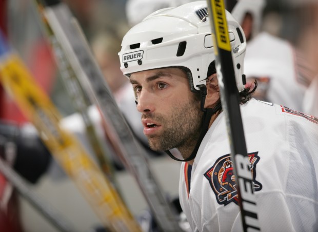 Oilers center Michael Peca watches play from the bench during a preseason game against the Canucks on Oct. 1, 2005, in Vancouver, British Columbia. (Jeff Vinnick/Getty Images)