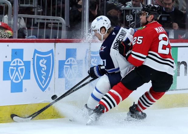 Jets center Vladislav Namestnikov, left, and Blackhawks defenseman Alec Martinez battle along the boards in the second period on April 12, 2025, at the United Center. (Chris Sweda/Chicago Tribune)