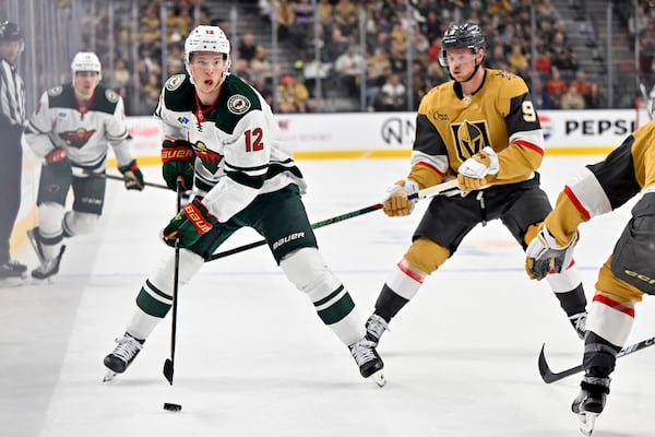 Minnesota Wild left wing Matt Boldy (12) handles the puck against Vegas Golden Knights center Jack Eichel (9) during the first period of Game 5 of a first-round NHL hockey playoff series Tuesday, April 29, 2025, in Las Vegas. (AP Photo/David Becker)