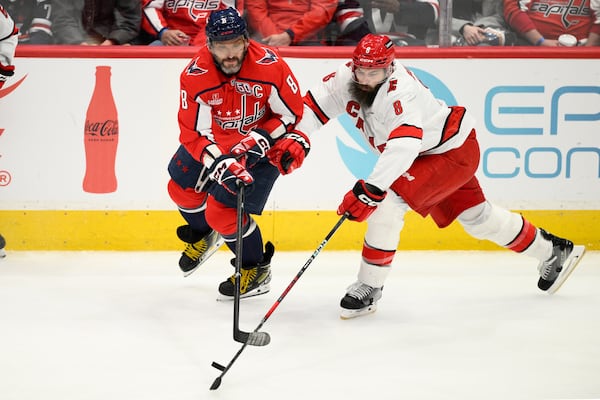 Washington Capitals left wing Alex Ovechkin, left, and Carolina Hurricanes defenseman Brent Burns, right, battle for the puck during the third period of an NHL hockey game, Thursday, April 10, 2025, in Washington. (AP Photo/Nick Wass)