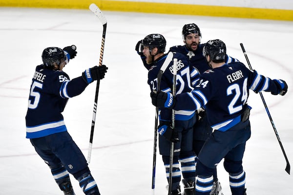 Winnipeg Jets' Nikolaj Ehlers (27) celebrates after his goal against the Dallas Stars with Mark Scheifele (55), Haydn Fleury (24) and Dylan Demelo (2) during the first period of Game 2 of a second-round NHL hockey playoff series in Winnipeg, Manitoba, Friday, May 9, 2025. (Fred Greenslade/The Canadian Press via AP)