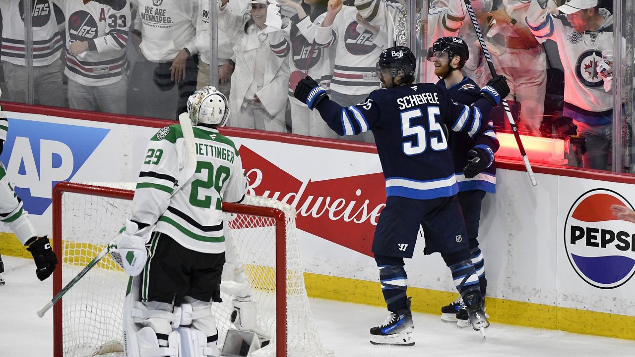 Winnipeg Jets' Mark Scheifele (55) celebrates his goal against Dallas Stars goaltender Jake Oettinger (29) with Kyle Connor (81) during second period NHL playoff hockey action in Winnipeg, Thursday, May 15, 2025. (Fred Greenslade/The Canadian Press via AP)