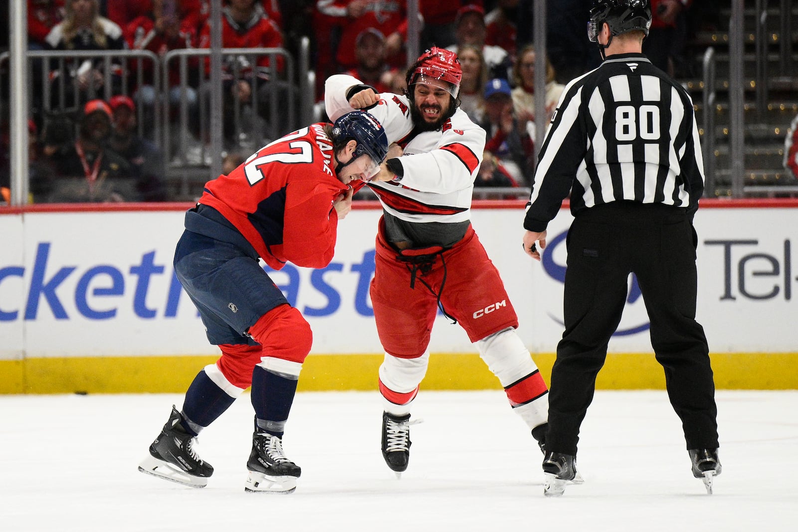 Washington Capitals right wing Brandon Duhaime (22) and Carolina Hurricanes defenseman Jalen Chatfield, center, fight during the first period of an NHL hockey game, Thursday, April 10, 2025, in Washington. (AP Photo/Nick Wass)