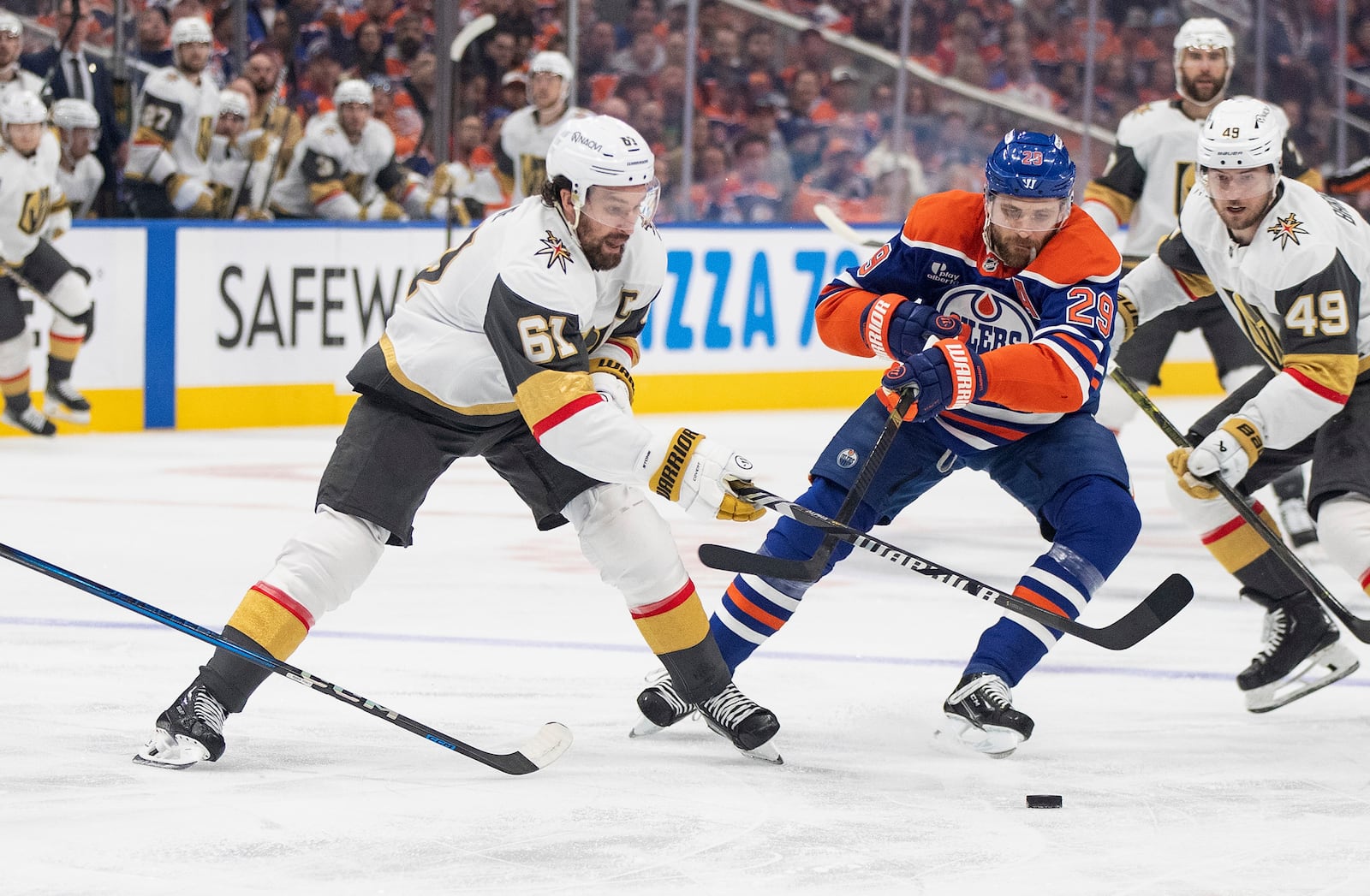 Vegas Golden Knights' Mark Stone (61) and Edmonton Oilers' Leon Draisaitl (29) battle for the puck during the first period of Game 4 of a second-round NHL hockey playoff series in Edmonton, Alberta, Monday, May 12, 2025. (Jason Franson/The Canadian Press via AP)