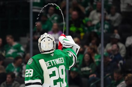 Dallas Stars goaltender Jake Oettinger squirts water during the second period of an NHL...