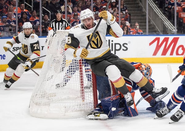 Vegas Golden Knights' Reilly Smith (19) falls over Edmonton Oilers goalie Stuart Skinner, center bottom, during the first period of Game 3 of a second-round NHL hockey playoff series in Edmonton, Alberta, Saturday, May 10, 2025. (Jason Franson/The Canadian Press via AP)
