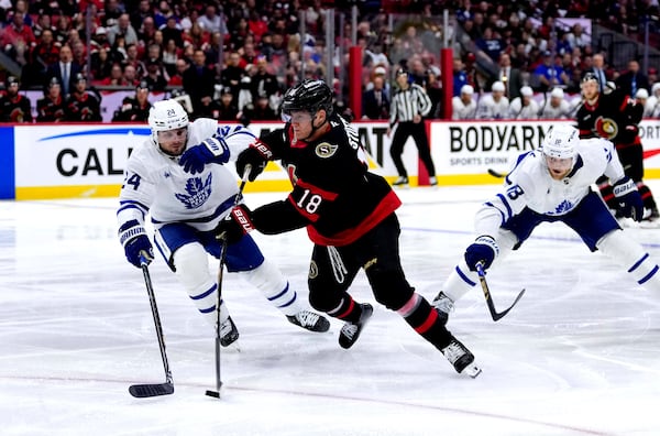 Ottawa Senators' Tim Stutzle (18) shoots against Toronto Maple Leafs' Scott Laughton (24) and Steven Lorentz (18) during the second period of Game 6 of a first-round NHL hockey playoff series in Ottawa, Ontario, Thursday, May 1, 2025. (Justin Tang/The Canadian Press via AP)