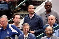Dallas Mavericks general manager Nico Harrison (standing, second from right) watches the...