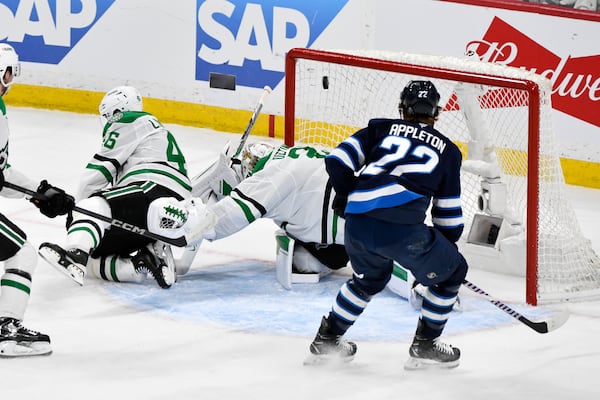 A shot by Winnipeg Jets' Adam Lowry (not shown) gets past Dallas Stars goaltender Jake Oettinger (29) for a goal during second period NHL playoff hockey action in Winnipeg, Friday, May 9, 2025. (Fred Greenslade/The Canadian Press via AP)