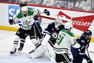 Dallas Stars' Jamie Benn (14) crashes into the net behind Winnipeg Jets goaltender Connor...
