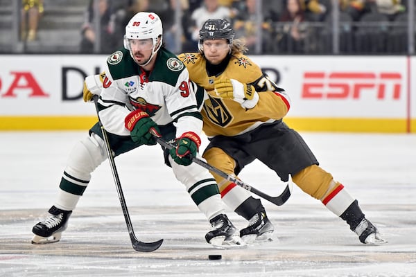 Minnesota Wild left wing Marcus Johansson (90) and Vegas Golden Knights center William Karlsson (71) vie for the puck during the second period of Game 5 of a first-round NHL hockey playoff series Tuesday, April 29, 2025, in Las Vegas. (AP Photo/David Becker)