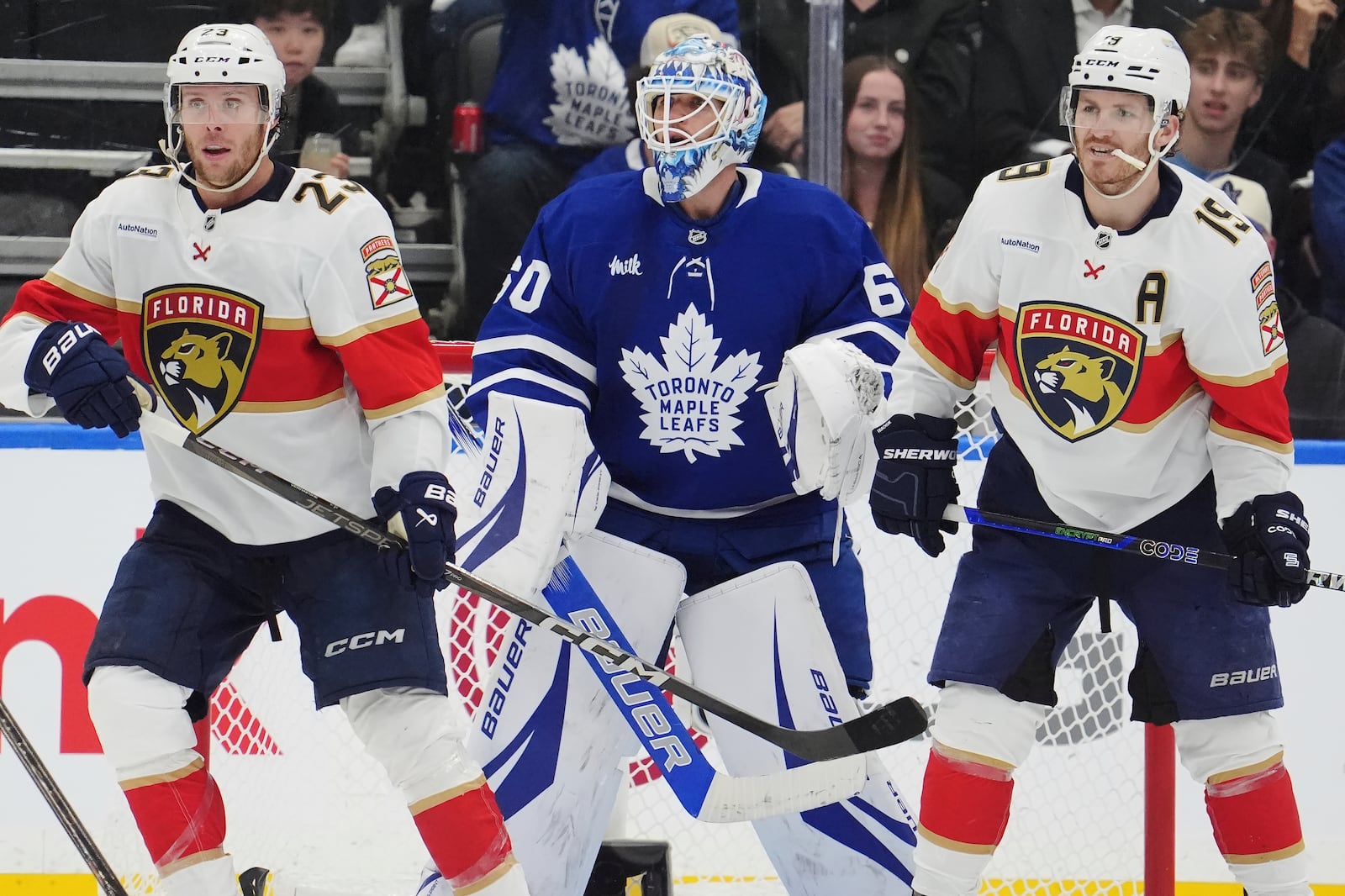 Toronto Maple Leafs goaltender Joseph Woll (60) looks through Florida Panthers' Carter Verhaeghe (23) and Matthew Tkachuk (19) during second period NHL playoff hockey action in Toronto on Wednesday, May 7, 2025. (Frank Gunn/The Canadian Press via AP)