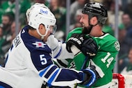 Dallas Stars left wing Jamie Benn (14) tangles with Winnipeg Jets defenseman Luke Schenn (5)...
