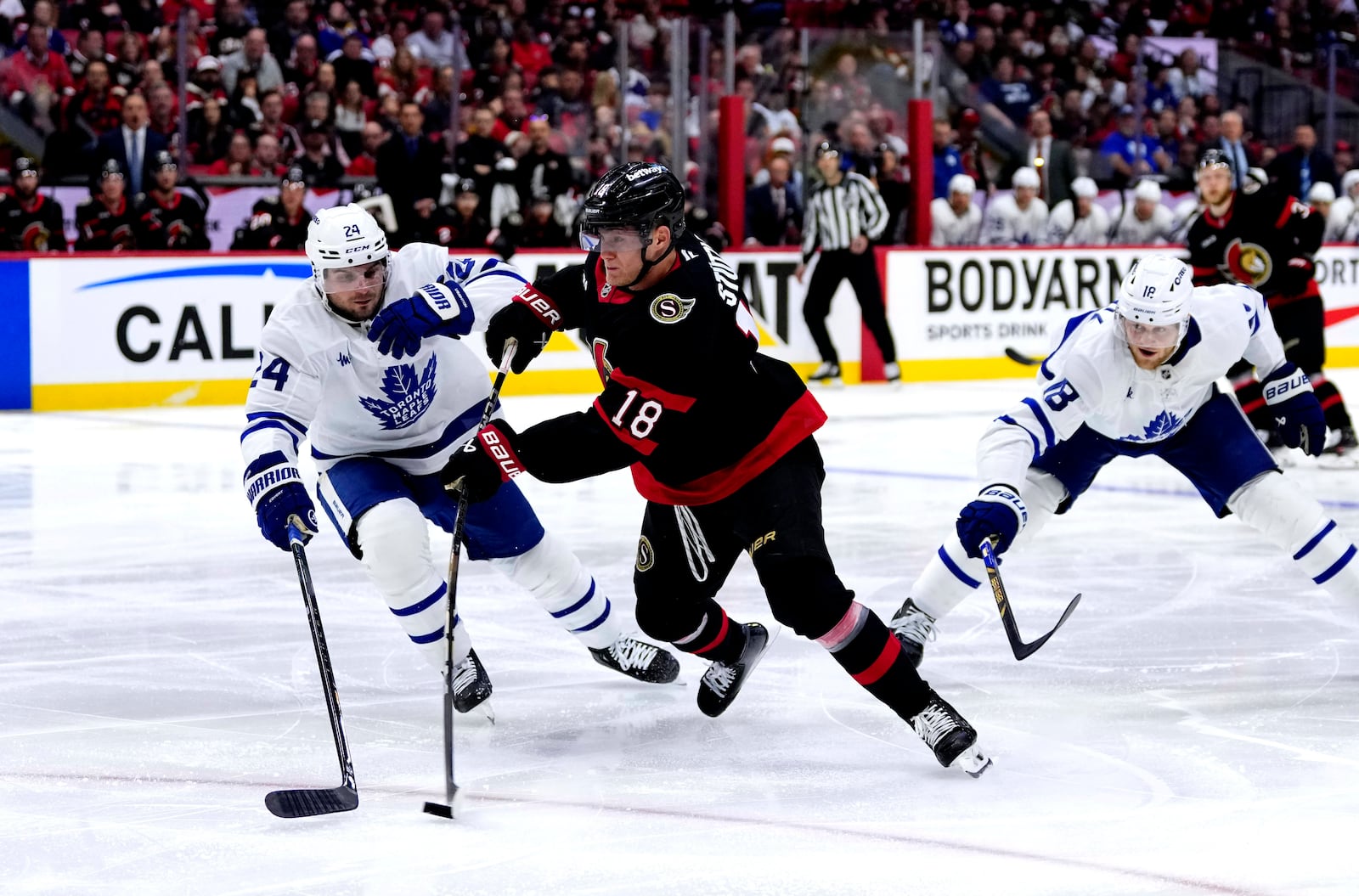 Ottawa Senators' Tim Stutzle (18) shoots against Toronto Maple Leafs' Scott Laughton (24) and Steven Lorentz (18) during the second period of Game 6 of a first-round NHL hockey playoff series in Ottawa, Ontario, Thursday, May 1, 2025. (Justin Tang/The Canadian Press via AP)